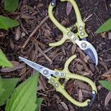 Pair of garden shears with green handles on a mulched surface