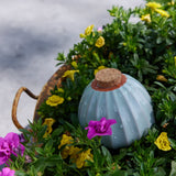 Decorative Terracotta Watering Bulb with cork lid surrounded by greenery and flowers