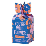 Colorful 'You're Wild Flower' seed bomb packaging with floral designs on a white background