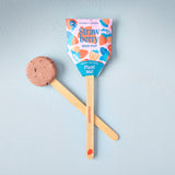 Seed pop with a wooden stick and strawberry-themed packaging on a light blue background