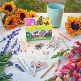 Butterfly-themed story garden kit with sunflowers, pencils, and a cup on a wooden table. Magical Minds Garden Kits