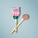 Seed pop with pink packaging and wooden stick on a light blue background Seed Pops - Flowers