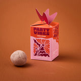 Seed bomb with 'Party Vibes' packaging on an orange background
