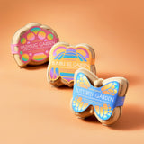 Three butterfly-shaped garden planters with colorful labels on an orange background Curious Critters Garden Kits