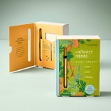 Seed library packaging with a pen and open book on a light gray background