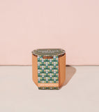 Tiny Terracotta Kits with patterned lid on a light pink background