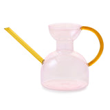 Pink Glass Watering Can with yellow handle and spout on a white background