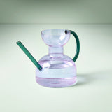 Clear glass water pipe with green accents on a light gray background