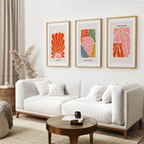 Modern living room with a white sofa, wooden coffee table, and Henri Matisse Flower Market Colorful Poster