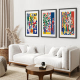 Living room with a white sofa, wooden coffee table, and Modern Colorful Floral Matisse Wall Art Set on the wall.