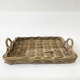 A rectangular woven wicker tray with two loop handles, shown on a plain white background.