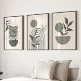 Three framed abstract plant art pieces on a wall above a sofa.