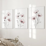 Three floral wall art prints on a white wall.