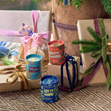 Gifts with ribbons and 'Spirits Bright' and 'Let It Grow' containers on a textured surface.