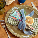 Butterfly pea flower tea package on a plate with checkered napkins and a dried orange slice. Seed Pops - Pollinator