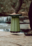 Person stepping onto a green portable Nomad Seat | Moss Green in a natural setting