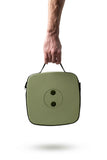Green carrying case with a Nomad Seat | Moss Green held by a hand on a white background