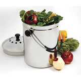 Small metal compost bin filled with food scraps on a white background