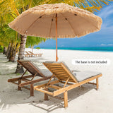 Beach scene with wooden lounge chairs and a thatched umbrella on a sandy beach with palm trees and blue sky.