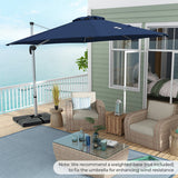 Outdoor patio with wicker chairs, table, and navy blue umbrella on a deck overlooking water.