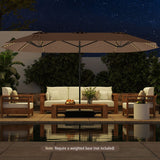 Outdoor patio set with furniture and umbrella by a pool at night