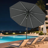 Dark gray patio umbrella with LED lights on a poolside deck at night.