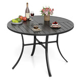 Round black outdoor table with various items on a white background