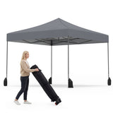 Person carrying a folded canopy with a gray outdoor canopy in the background