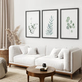Modern living room with a white sofa, wooden coffee table, and framed Watercolor Botanical Set of 3 Prints Wall Decor on the wall.
