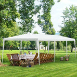 White outdoor canopy tent set up on a grassy area with tables and chairs underneath.
