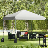 Outdoor canopy set up in a garden with furniture and grill