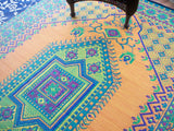 Colorful geometric Turkish Aqua patterned rug with intricate designs on a wooden floor.