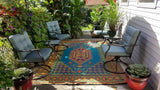 Outdoor patio with colorful Turkish Aqua rug, chairs, and potted plants