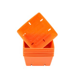 Stack of orange plastic pots on a white background