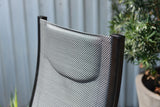 Close-up of a chair with woven backrest against a neutral background