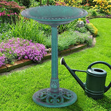 Decorative garden birdbath with a watering can on grass