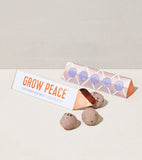 Grow Peace product packaging with two seed balls on a neutral background