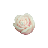 Pink rose-shaped candle on a white background