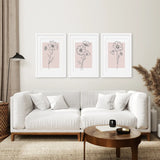 Living room with a white sofa, wooden coffee table, and Pink Wall Art Set Of 3 Botanical Modern Decor