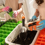 People working with soil and gardening tools in a greenhouse setting
