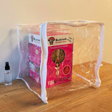 Pink mushroom growing kit in a clear plastic bag on a wooden surface.