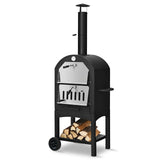Black outdoor wood-fired pizza oven with a wheel and stacked logs on a white background