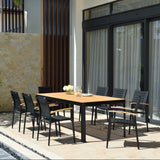 Outdoor dining set with a wooden table and black chairs on a patio.