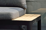 Gray cushioned chair with a wooden table on a blurred background