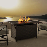 Fire pit table with flames on a patio at sunset