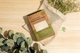 Mesh produce bag with packaging on a wooden surface with plants around