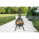 Outdoor metal chiminea on a pathway with greenery in the background
