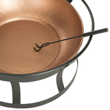 Copper fire pit with black metal stand and tool on a white background