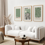 Modern living room with a white sofa, wooden coffee table, and framed Sage Green Exhibition Art Set of 3 Prints. Bauhaus, Kusama, Matisse