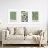 Beige sofa with decorative pillows and a blanket, featuring three framed Sage Green Exhibition Art Set of 3 Prints. Bauhaus, Kusama, Matisse
